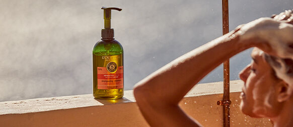 Woman using L'OCCITANE Intensive Repair Shampoo