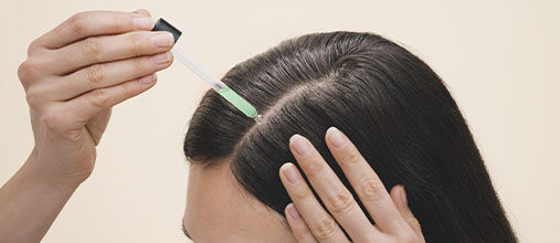 Woman applying L'OCCITANE Anti-hair loss Serum
