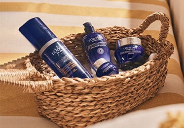 This image shows a basket full of the L'OCCITANE Immortelle Precious Cleansing Foam, L'OCCITANE Immortelle precious Eye Balm, L'OCCITANE Immortelle precious Eye cream.