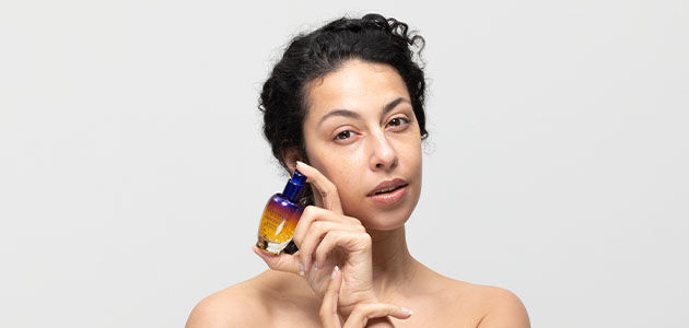 A woman holding the L'OCCITANE Overnight Reset Serum