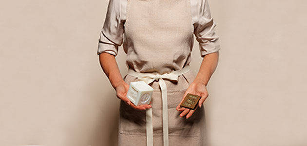 Craftswoman holding L'OCCITANE Bonne M&egrave;re Soap Bar and stamp used in the manufacturing process, Savon de Marseille, Provence