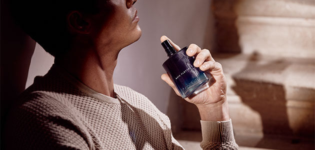 A man spritzing the L'OCCITANE mens Bois Flotte Eau de Toilette onto his neck