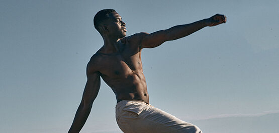 Man practising yoga on beach 