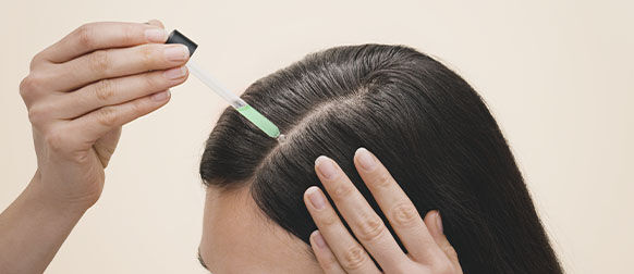 Woman applying L'OCCITANE Anti-hair loss Serum
