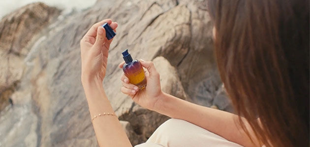 A woman holding the L'OCCITANE Immortelle Reset Overnight Serum