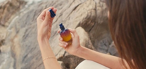 A woman holding the L'OCCITANE Immortelle Reset Overnight Serum